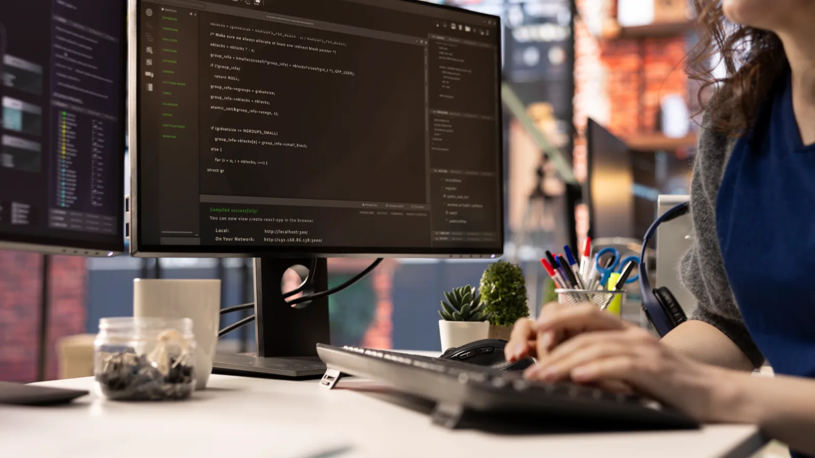 Developer reviewing a website file and code on a monitor