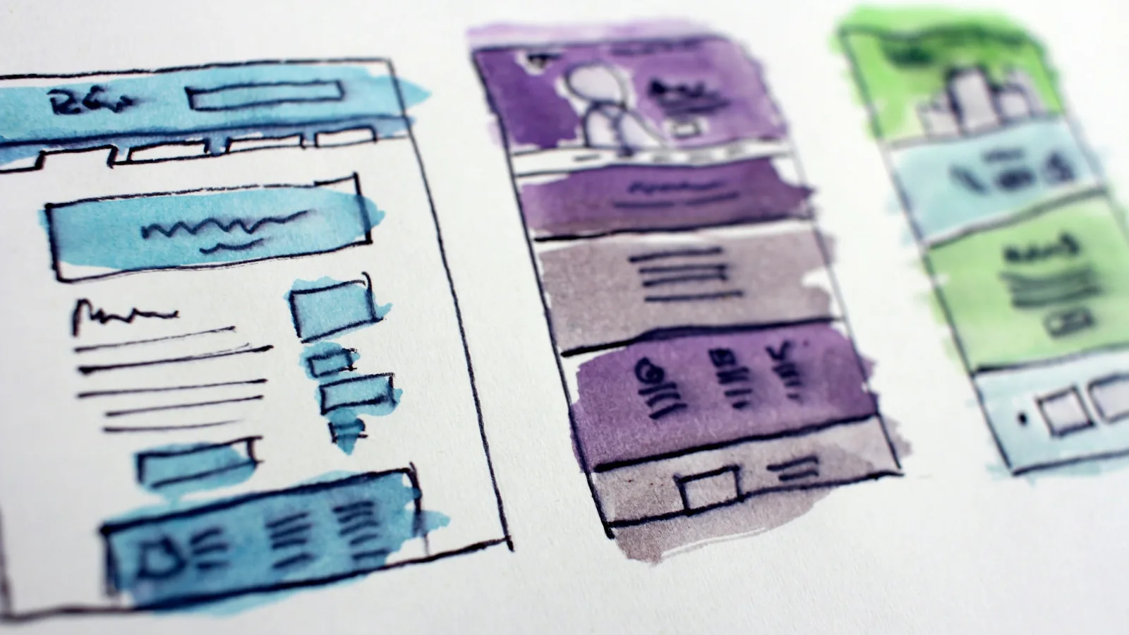 Hand-drawn wireframe sketches of website page layouts laid out side by side for comparison