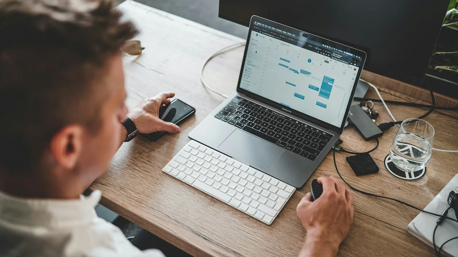 Business owner editing a website on a laptop while checking the mobile version on a phone
